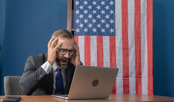 Mid adult man using mobile phone at table