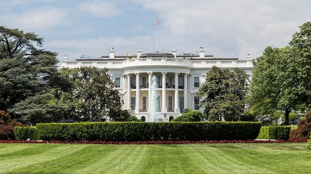 Grassy field with white house in background