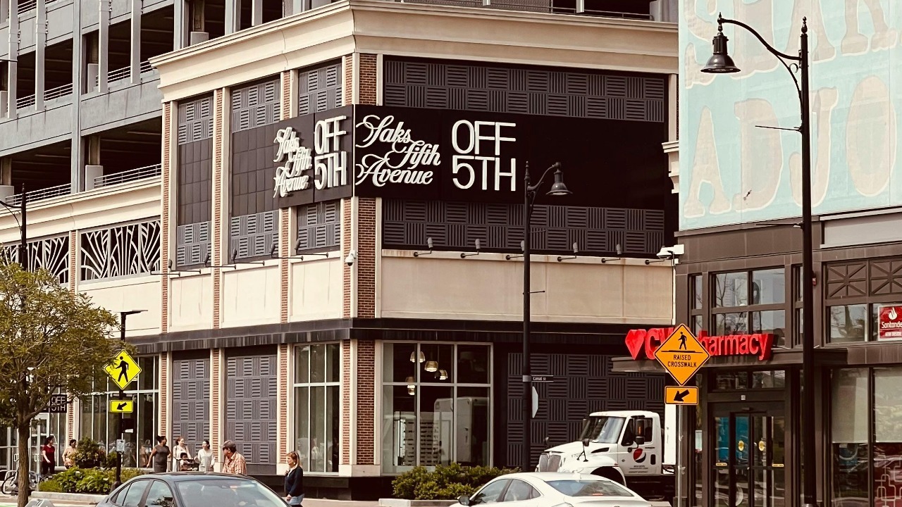 Street view of a modern building with prominent store signage on a busy urban street.