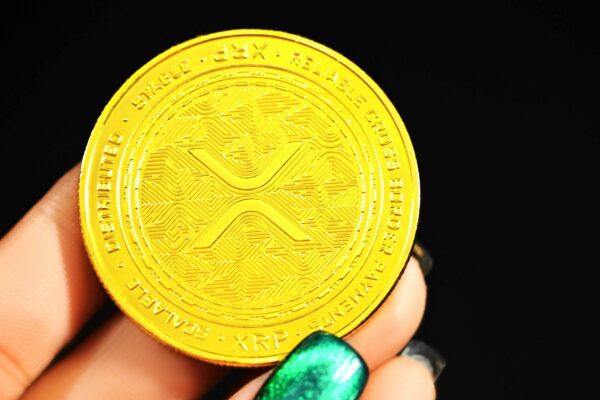gold round coin on persons hand