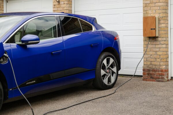 A blue electric car plugged in to a garage