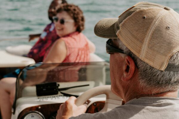 a man driving a boat with a woman on the back of it