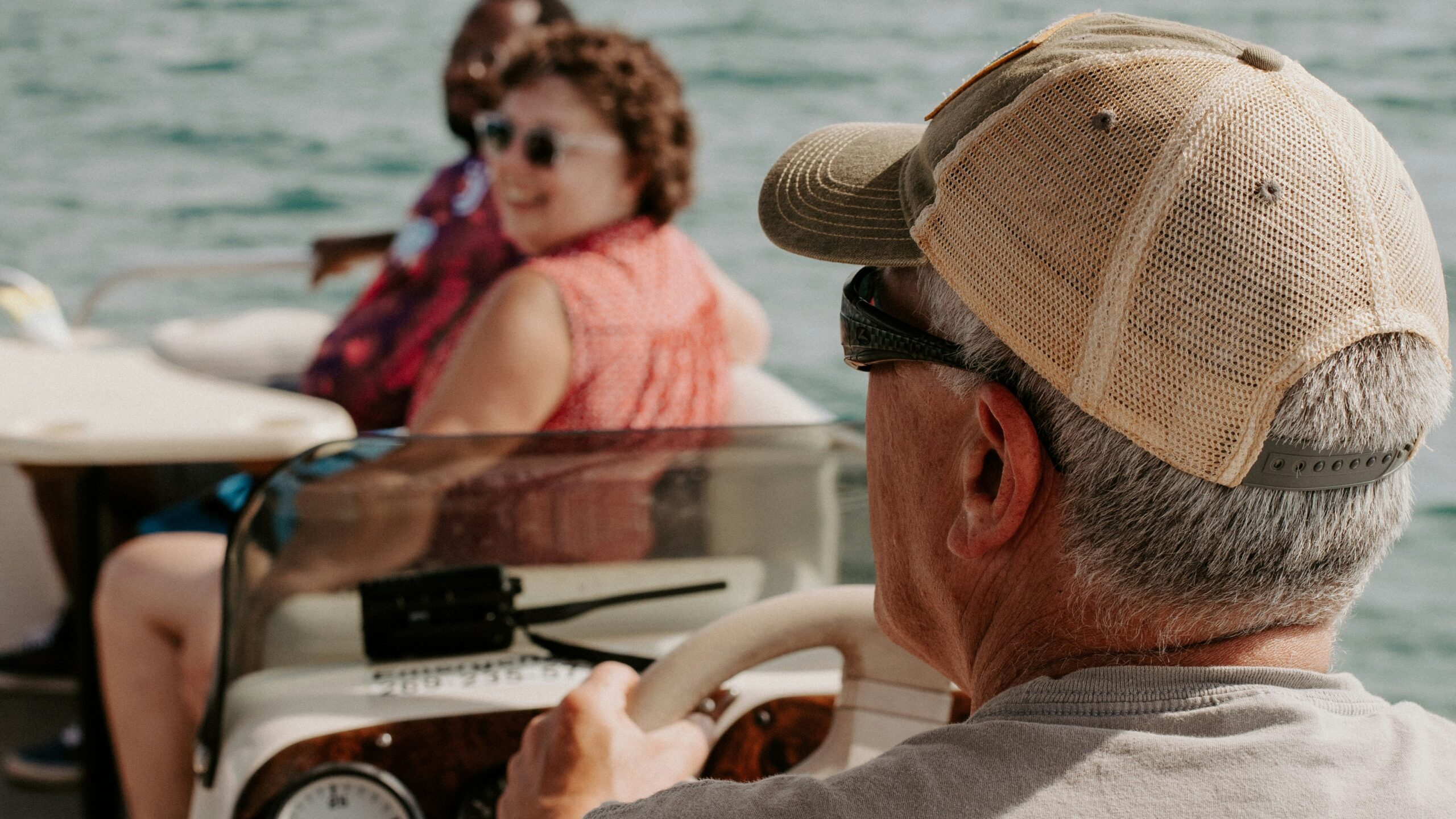 a man driving a boat with a woman on the back of it