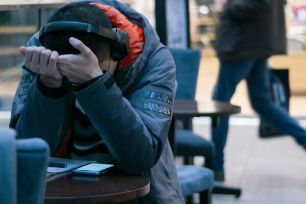 man sitting beside table with turned on smartphone