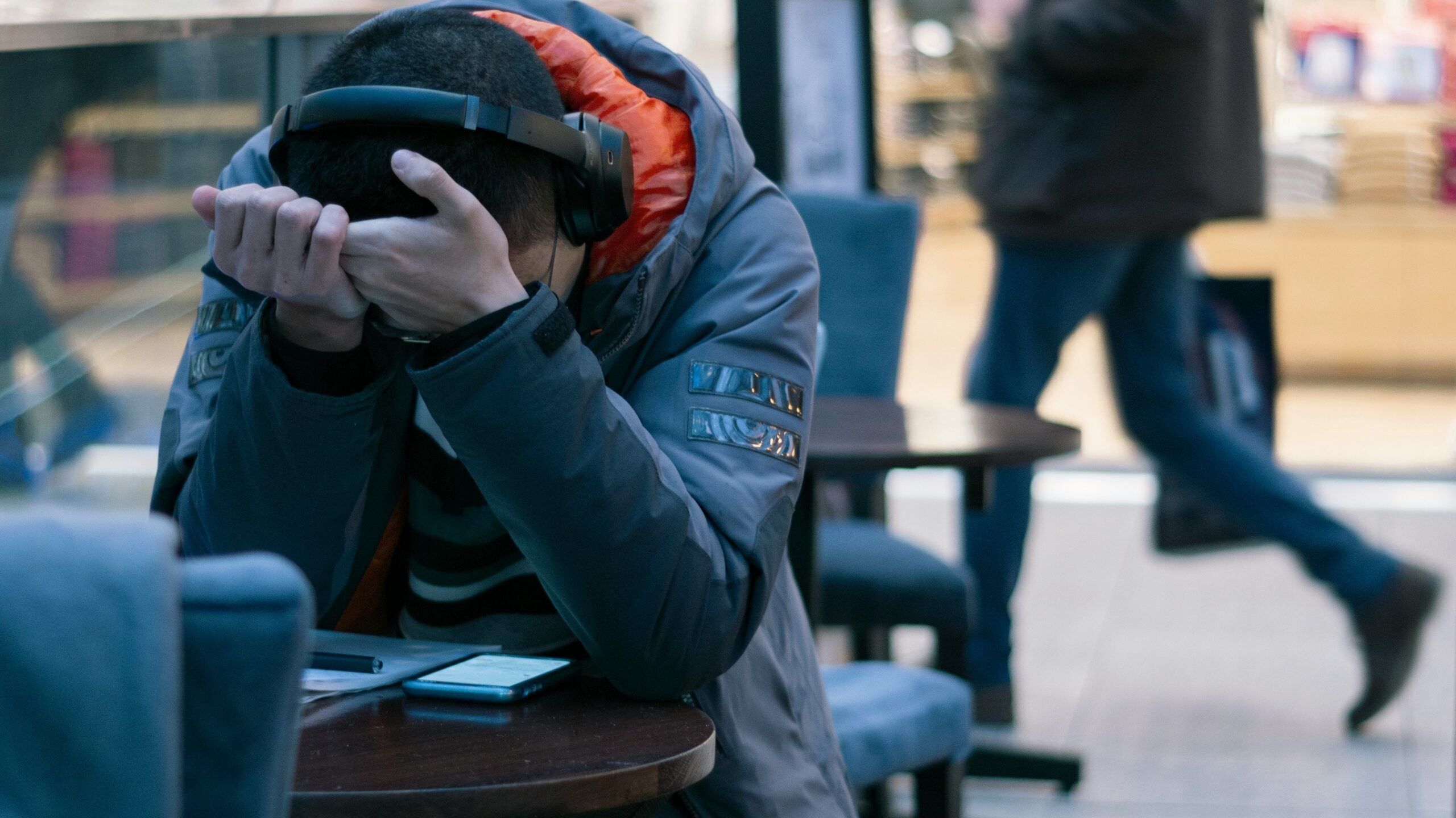 man sitting beside table with turned on smartphone
