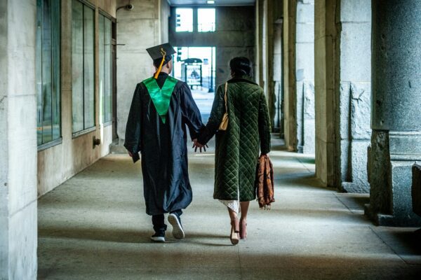 two people walking down a hallway holding hands