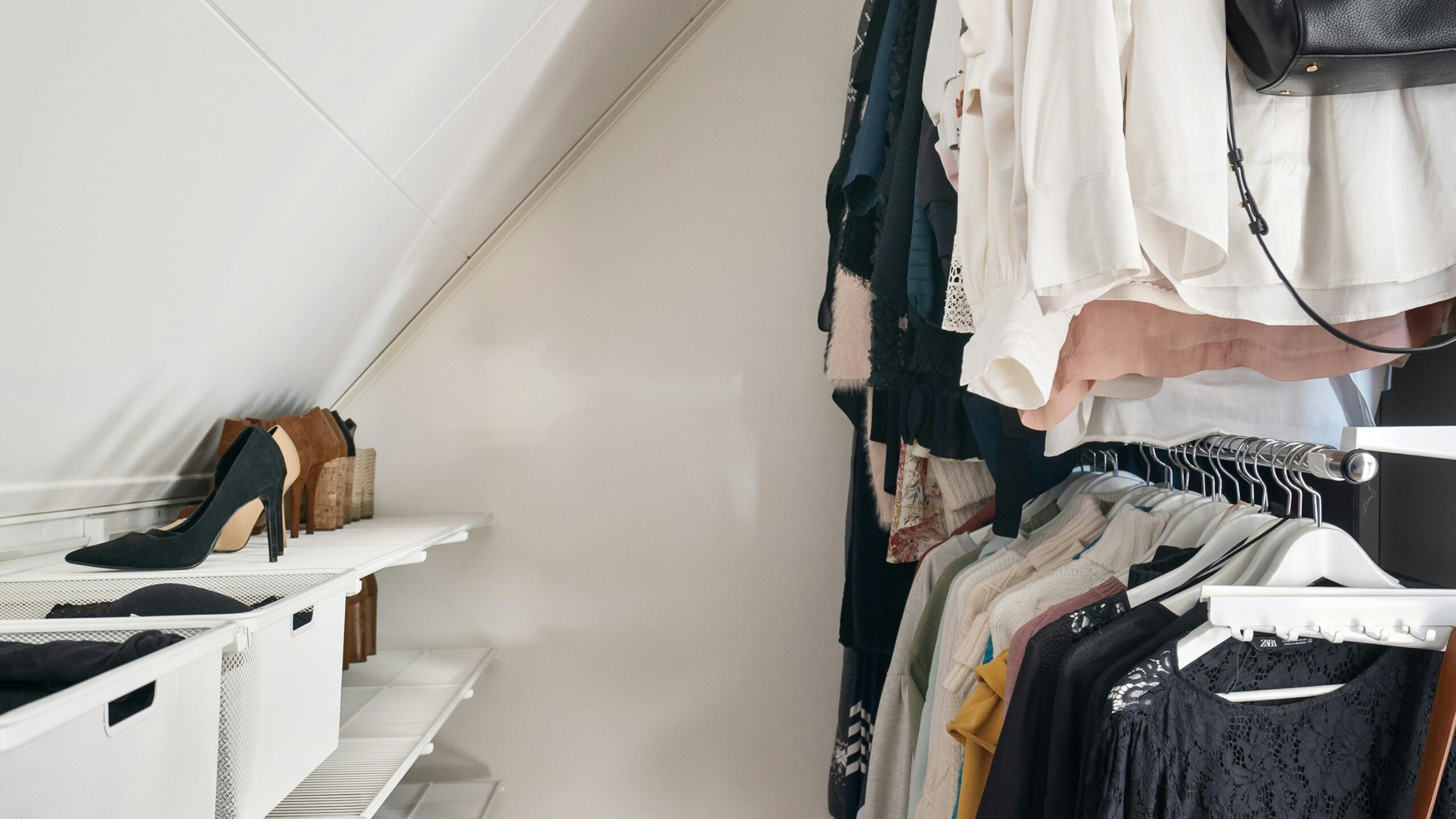 A closet filled with clothes and a handbag