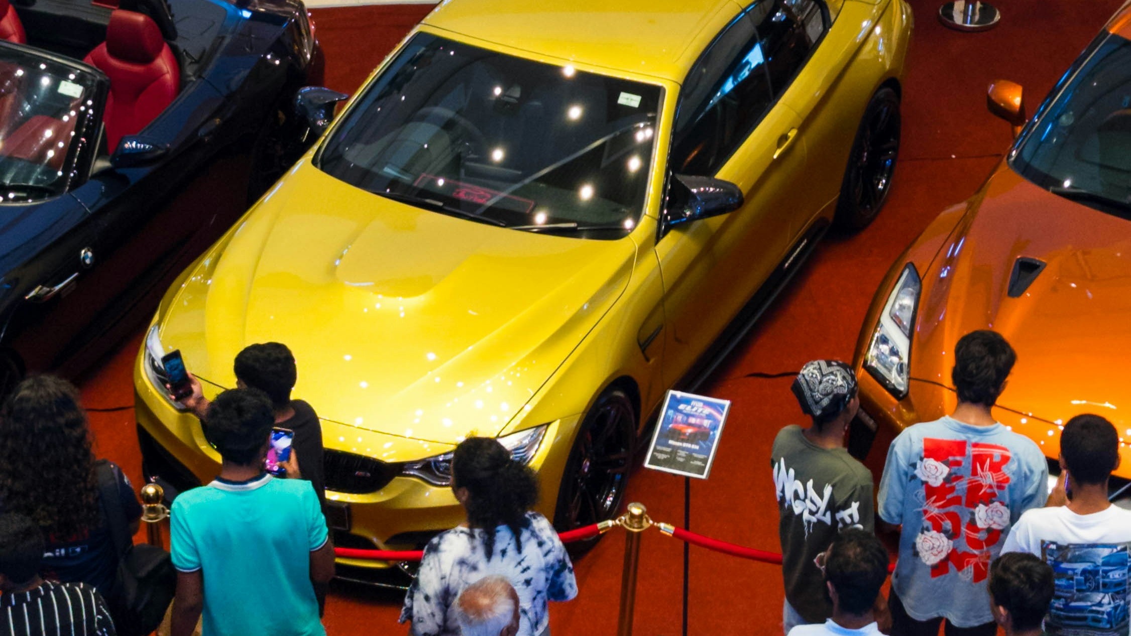 People are gathered to look at the cars.