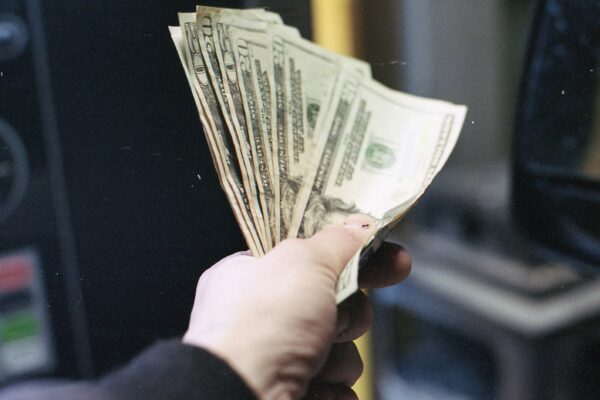 person holding fan of us dollar bill