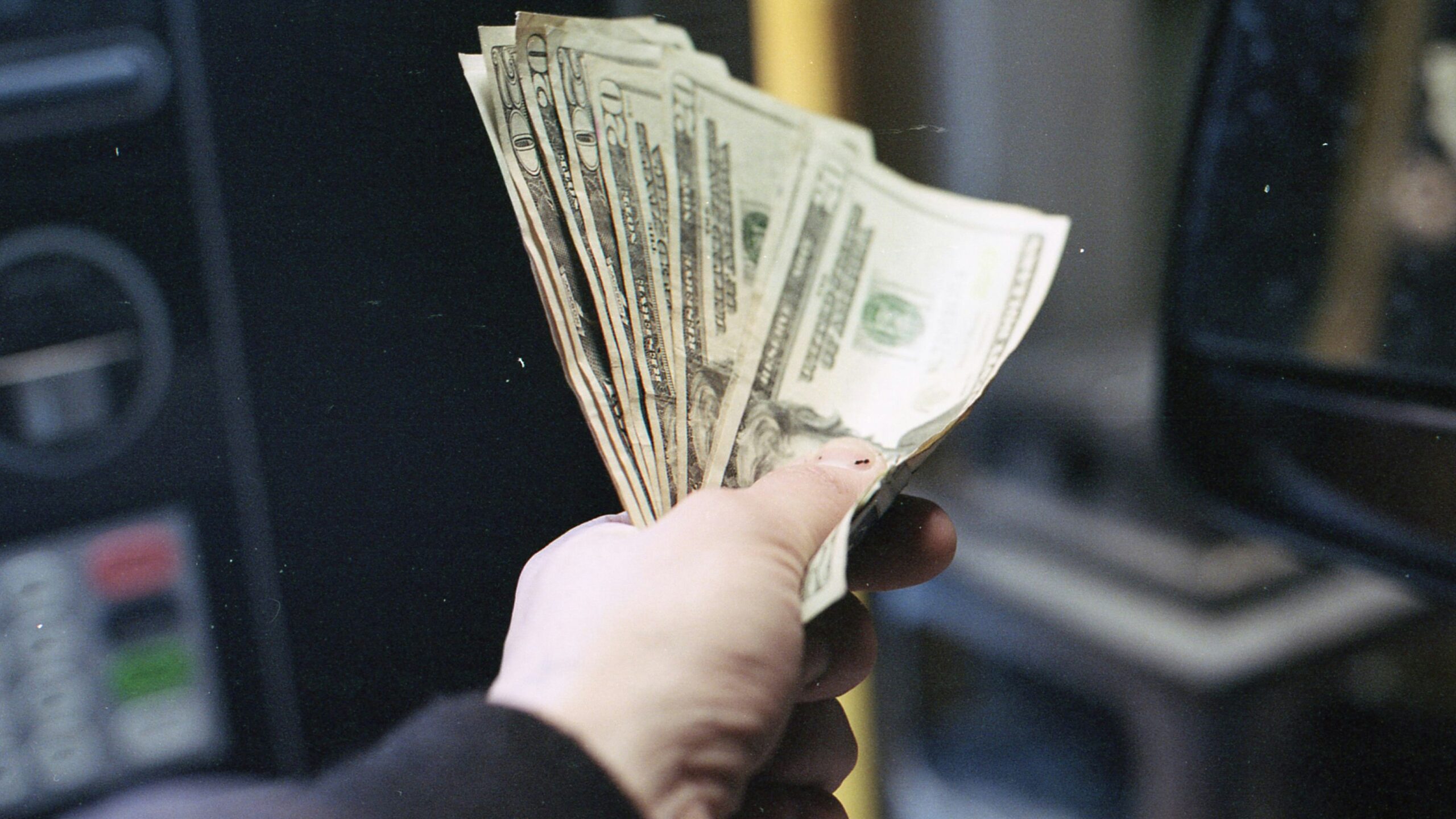 person holding fan of us dollar bill