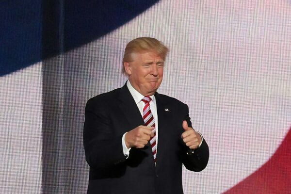 Donald Trump beside man in black suit