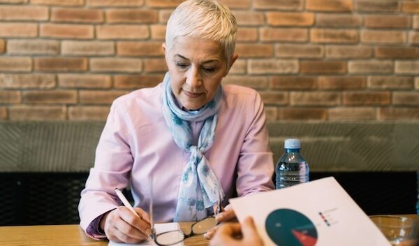 Beautiful senior businesswoman signing a contract for work after conducting a job interview.