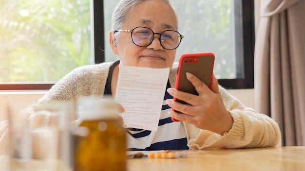 Senior woman checking prescription and find information about medicines by her phone