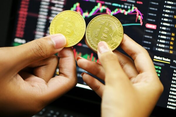 person holding gold round coin