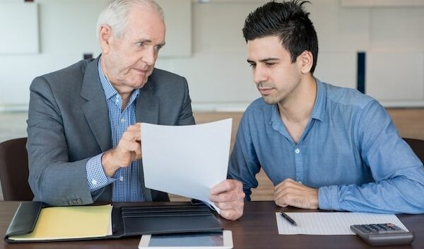 Serious boss explaining document to colleague