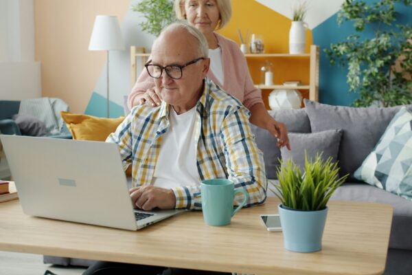 Elderly couple using a laptop together at home.
