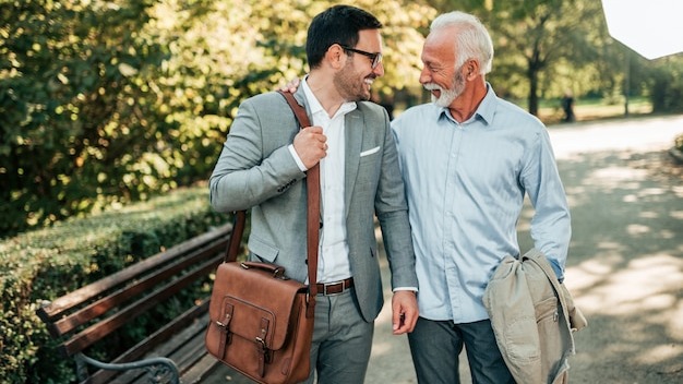 Two elegant men walking in the park.