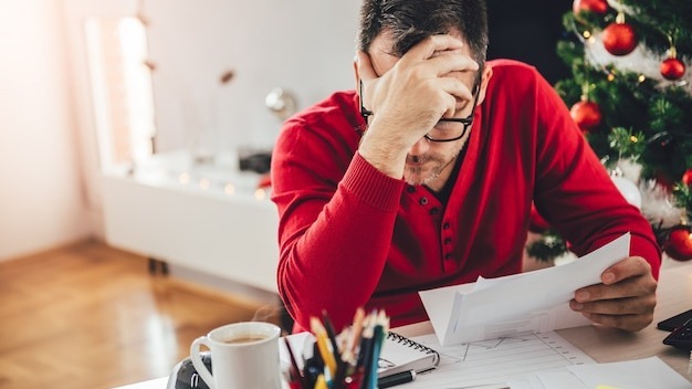 Man reading letter and holding hand at forehead