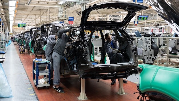 Car bodies are on assembly line Factory for production of cars Modern automotive industry A car being checked before being painted in a hightech enterprise