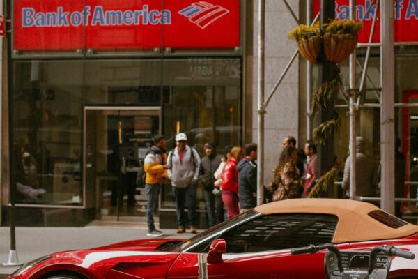 a red sports car is parked in front of a bank of america