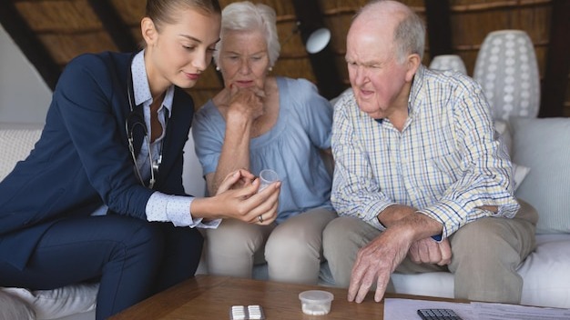 Female doctor and senior couple discussing over medicine