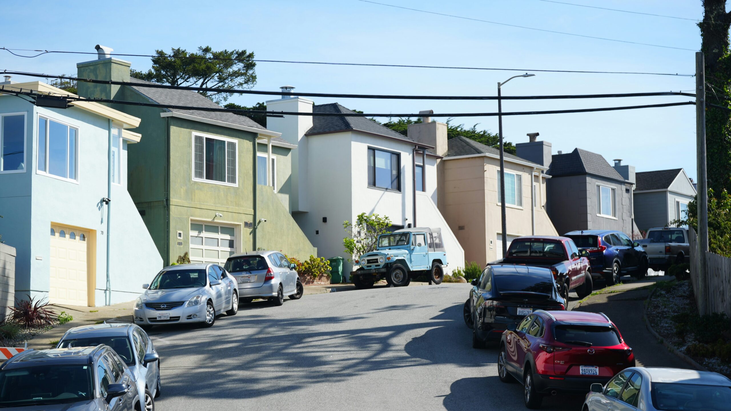 Cars parked on a residential street with houses.