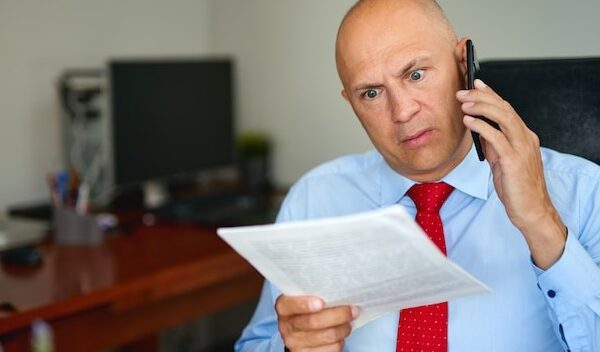 Man in blue shirt and red tie at office