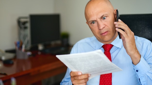 Man in blue shirt and red tie at office
