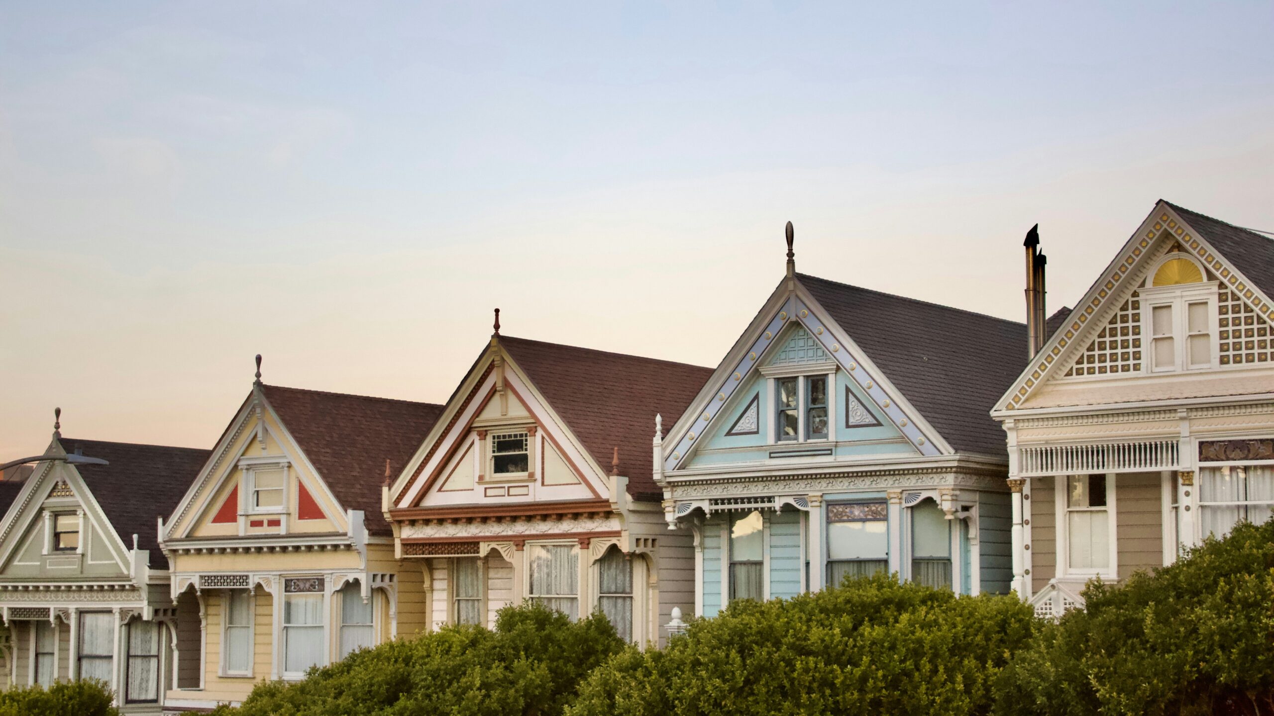 Colorful victorian houses stand in a row.