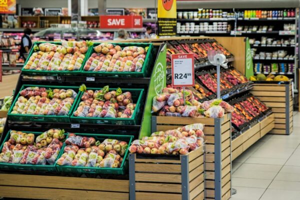 Colorful produce aisle in a supermarket showcasing fresh apples with discount signage.