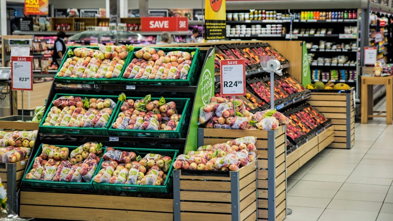 Colorful produce aisle in a supermarket showcasing fresh apples with discount signage.