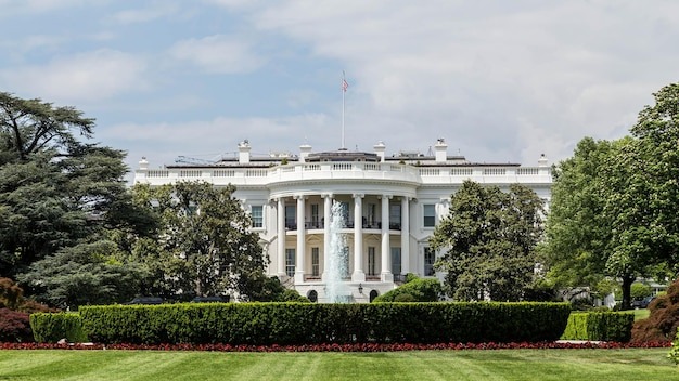 Grassy field with white house in background