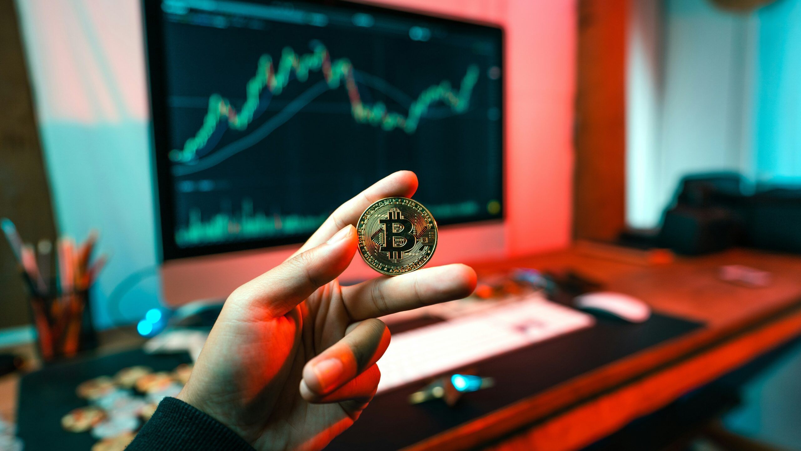 a person holding a coin in front of a computer