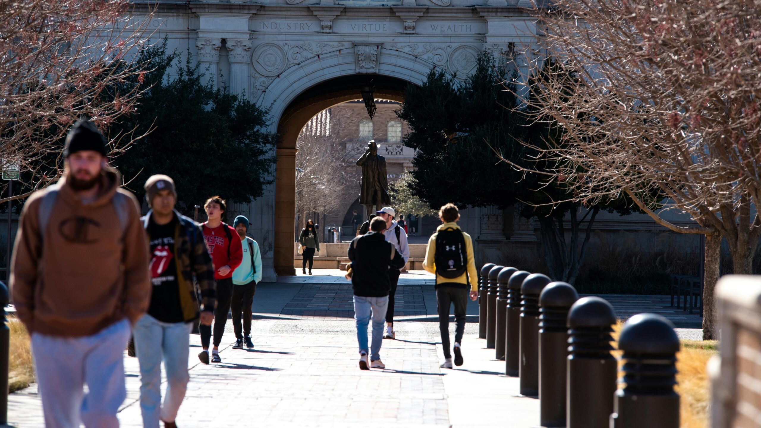 Students walking through a university campus archway