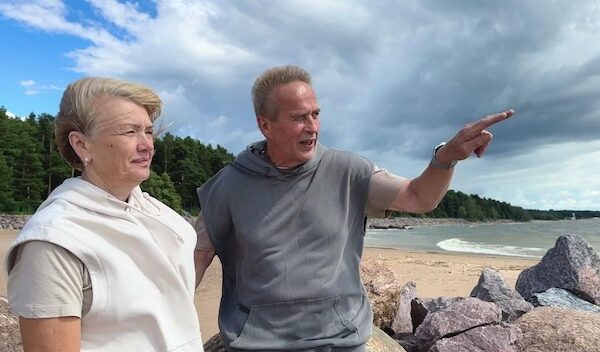 Portrait of happy elderly senior couple in love walking on a beach at summer smile laugh have fun