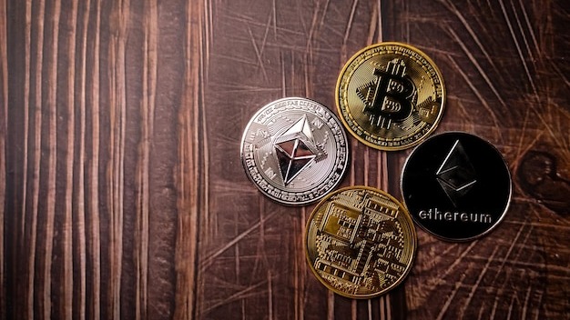 A beautiful silver ethereum and golden bitcoins digital crypto coin on wooden table with copy space
