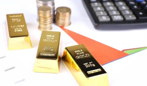 Gold bullion with coins on documents background