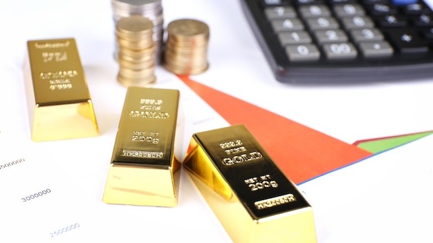 Gold bullion with coins on documents background