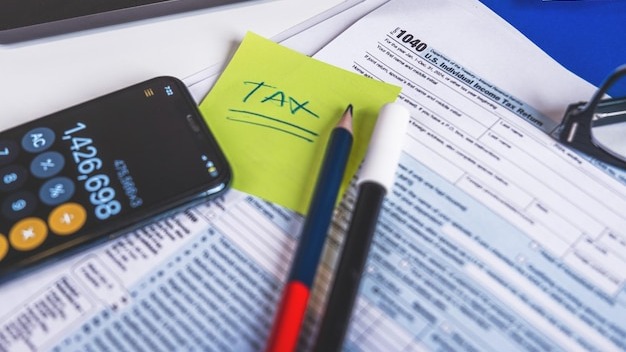 Tax form 1040 w9 pencil marker pen reading glasses and laptop are laying on accountants desk