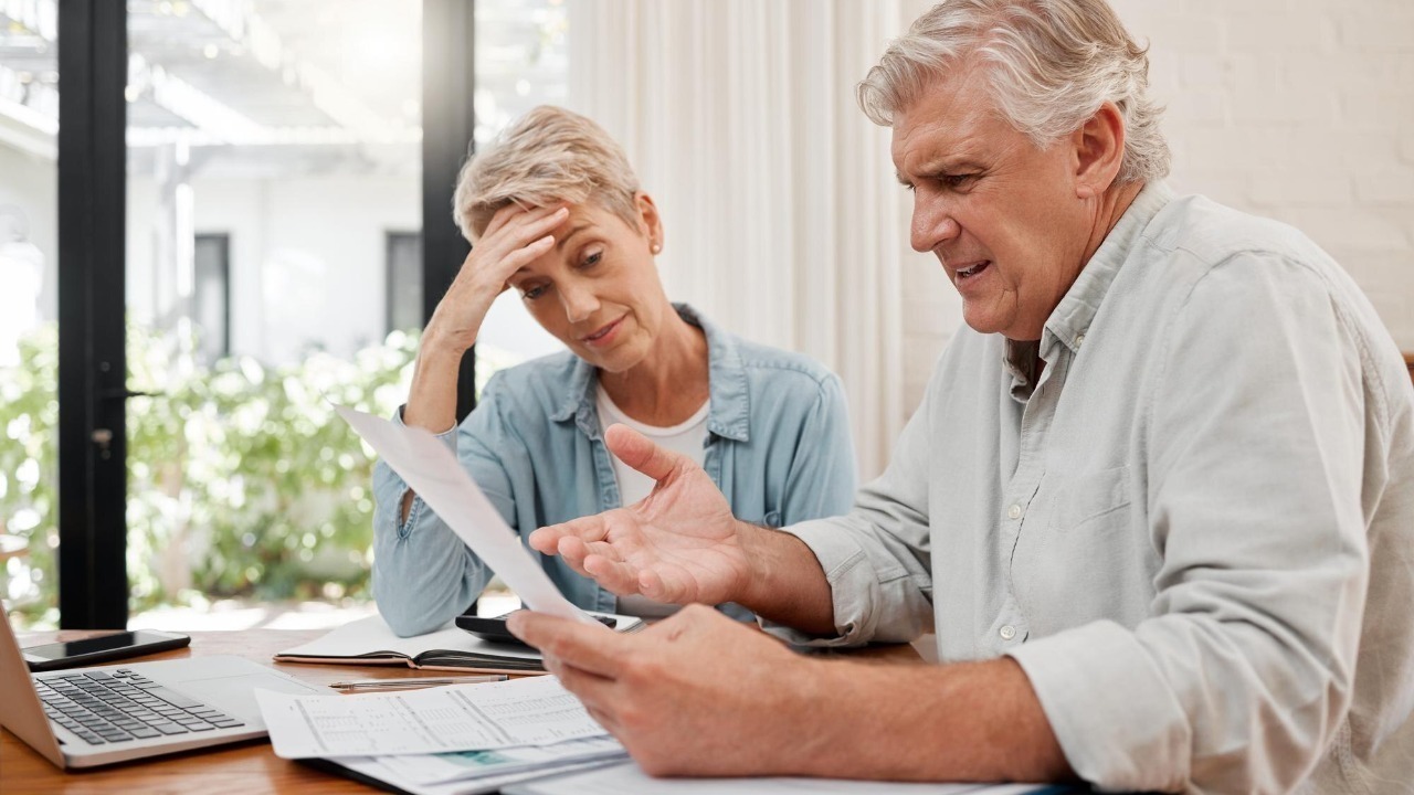 Sad retirement couple finance debt and anxiety in financial planning mortgage home loan and paper bills Stress woman angry man and senior people pension problem admin crisis and budget mistake
