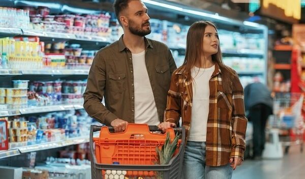 Choosing the products Young couple are in supermarket together