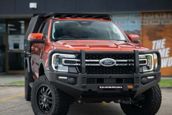 Orange ford truck with bull bar and roof rack