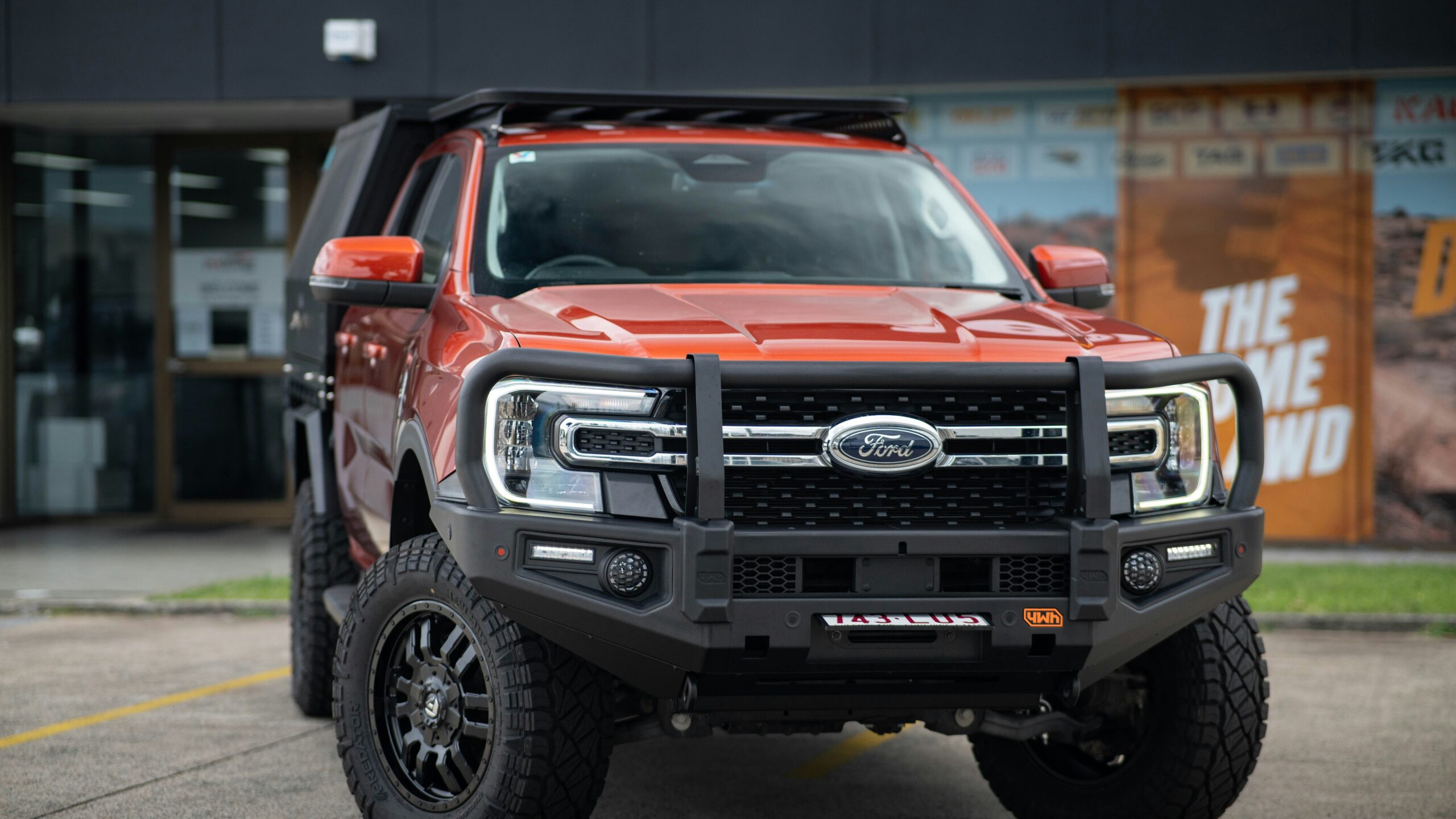 Orange ford truck with bull bar and roof rack