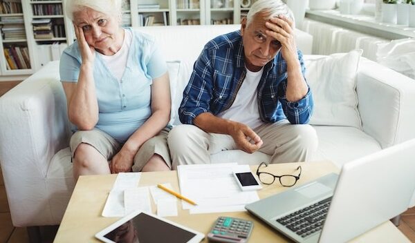 Worried senior couple sitting on sofa