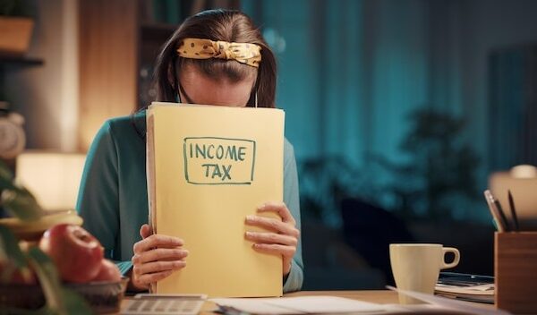 Frustrated woman checking tax documents at home