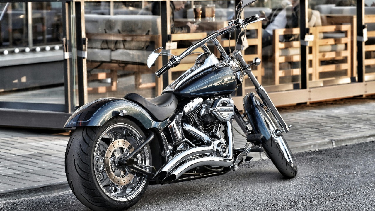 A sleek Harley-Davidson motorcycle parked on a city street, showcasing chrome detailing.
