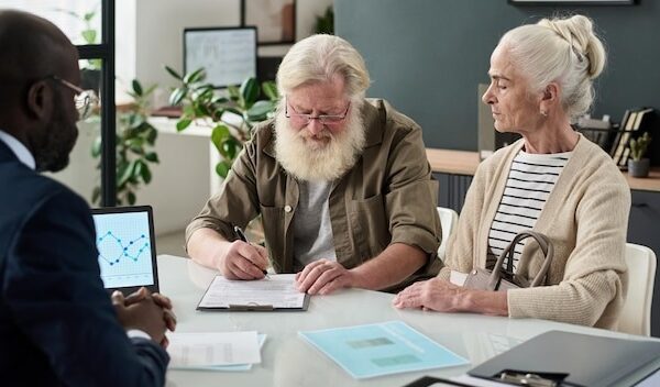 Senior couple concluding a contract in office