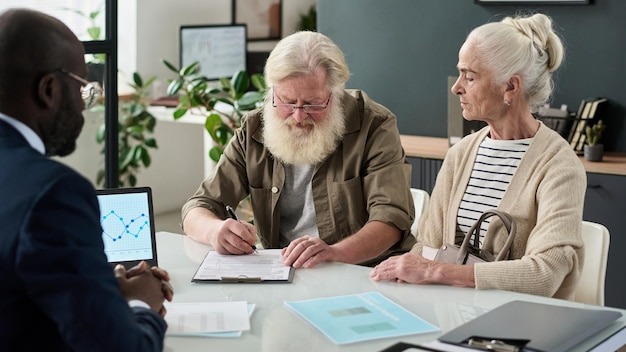 Senior couple concluding a contract in office