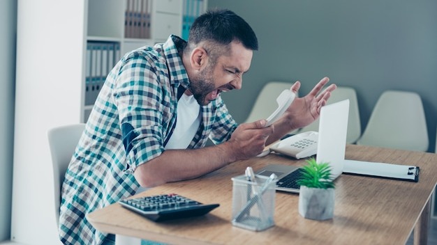 Employee with a blue checkered shirt working in the office
