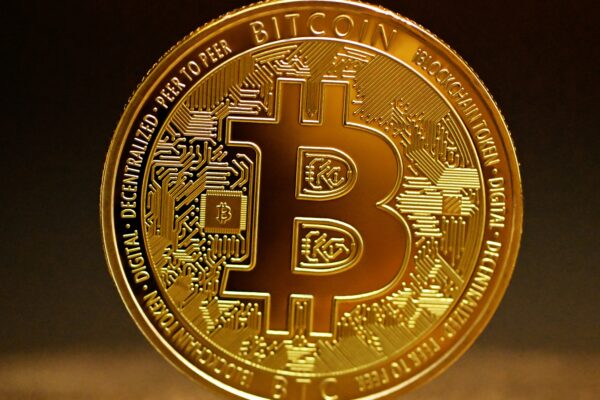 a golden bitcoin sitting on top of a table